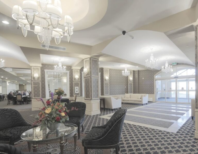 The elegant entrance at Trinity Manor Stonebridge, a Saskatoon retirement home. The entrance of this independent assisted living retirement residence features chandeliers, and a luxurious touch to comfortable, formal seating.